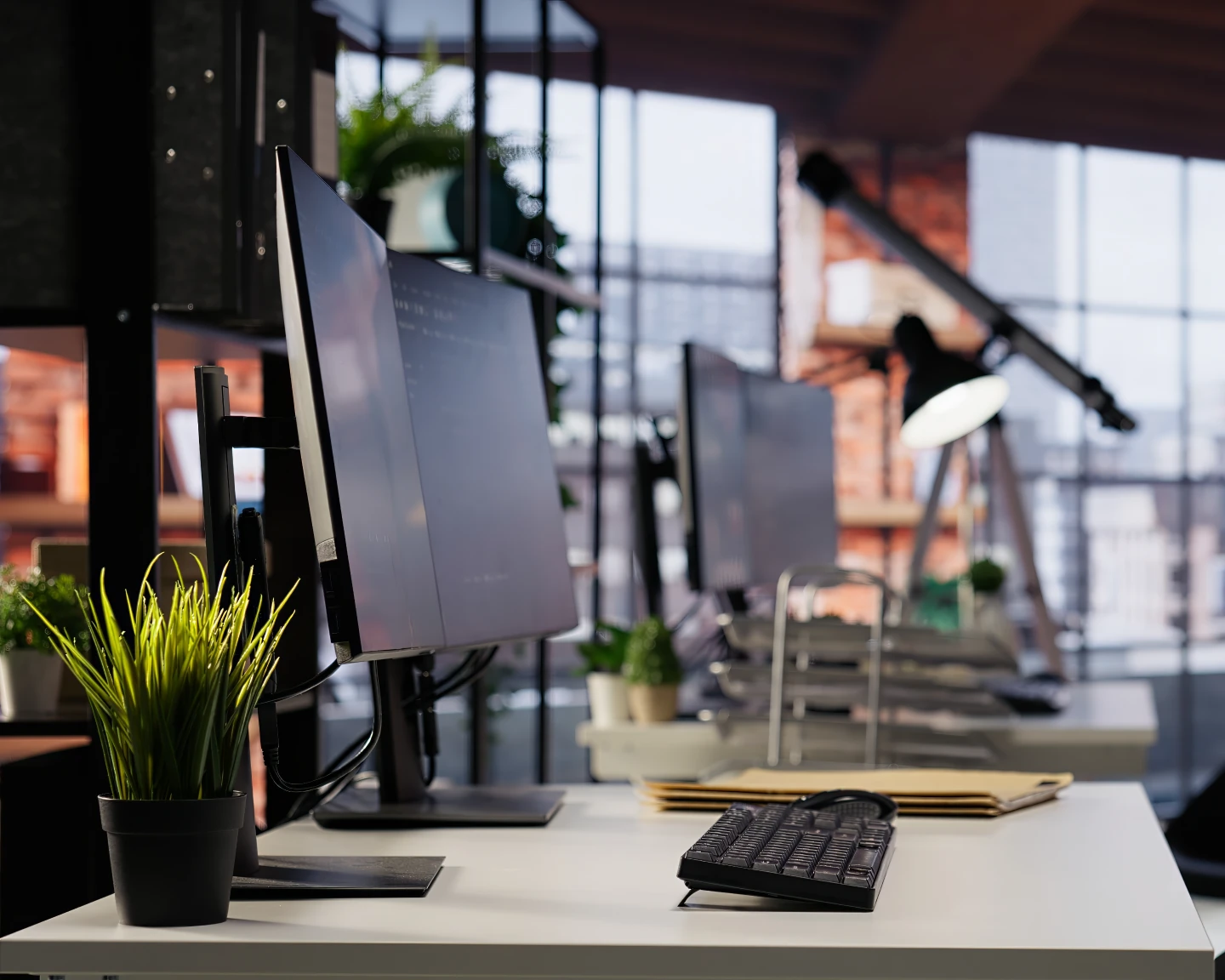Modern office workspace featuring a computer monitor, keyboard, potted plant, and folders on a desk. The background showcases shelves, a telescope, large windows, and subtle touches inspired by designeo aesthetics.